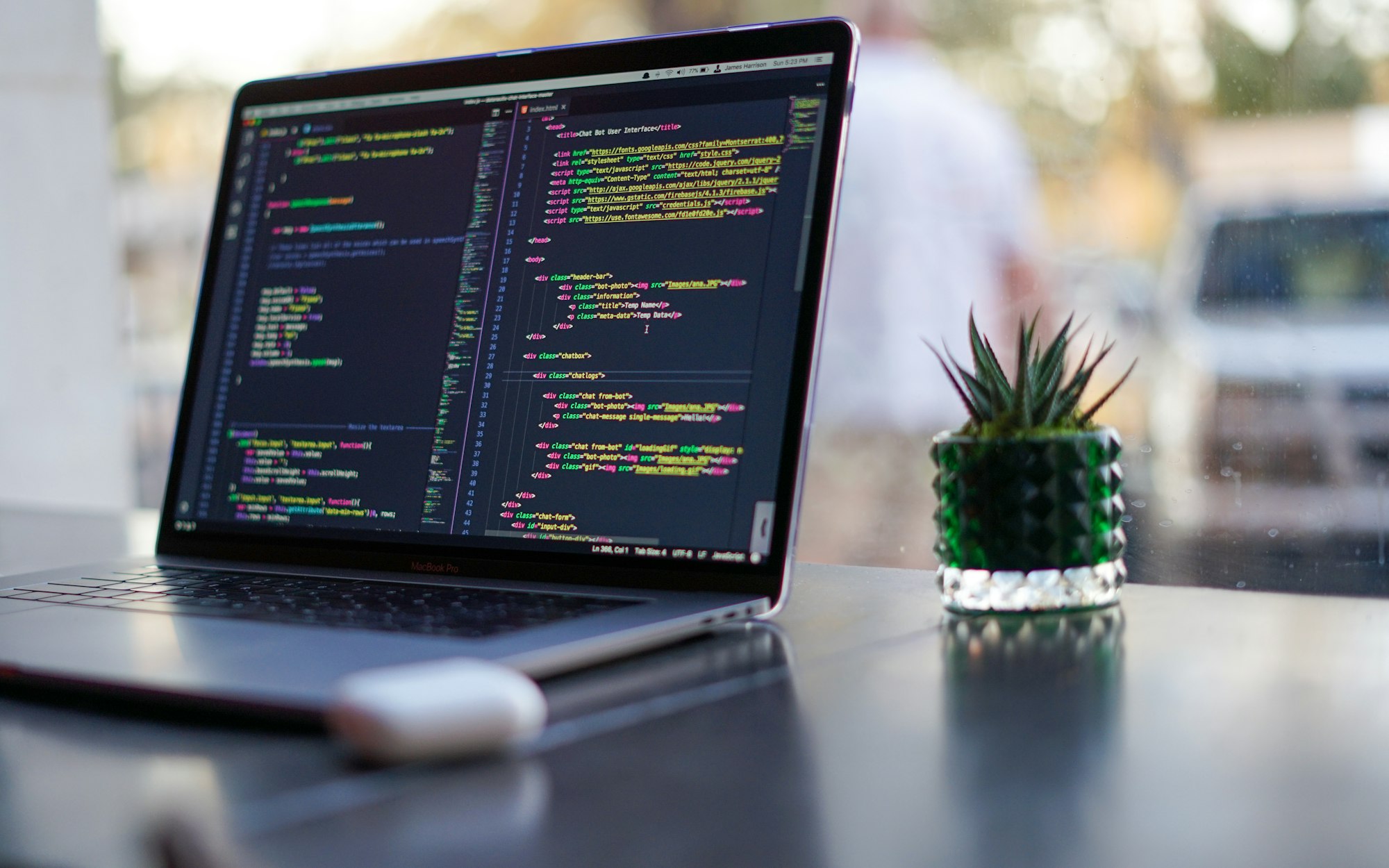 Placeholder photo: a MacBook on a desk with code on screen